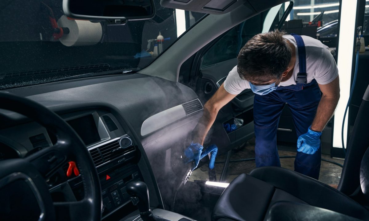 Man leaning and dry cleaning car salon near front seats